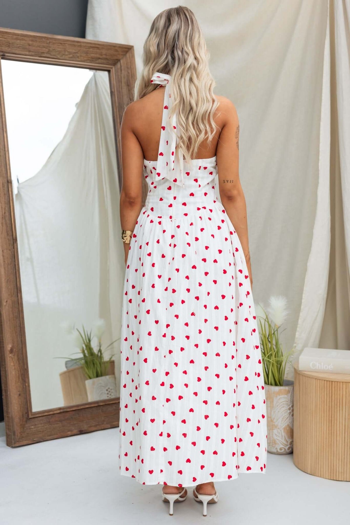 Back view of Imarnie Maxi Dress featuring a tie neckline and colorful heart prints on a white fabric.