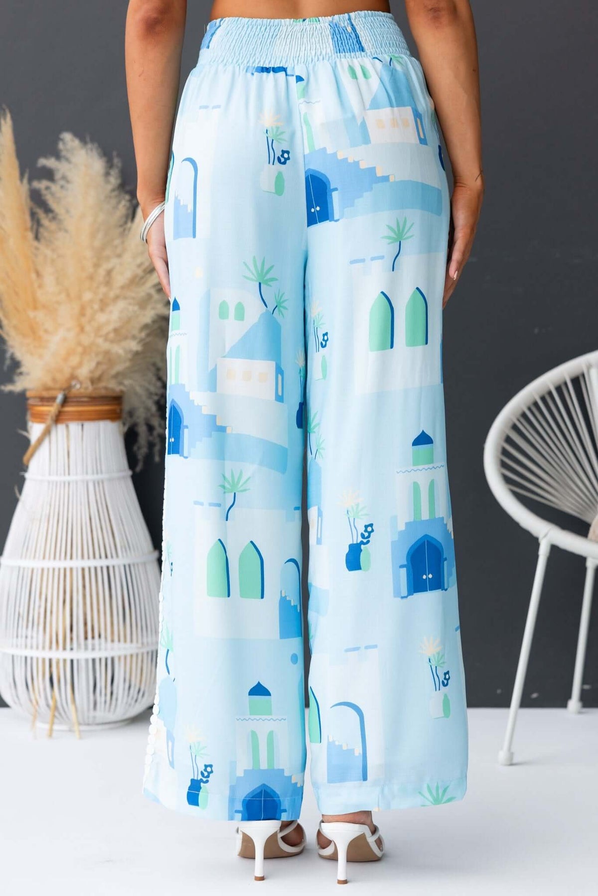 Rear view of Uriela Pants featuring a mid-high waist, elastic waistband, and a blue patterned design.