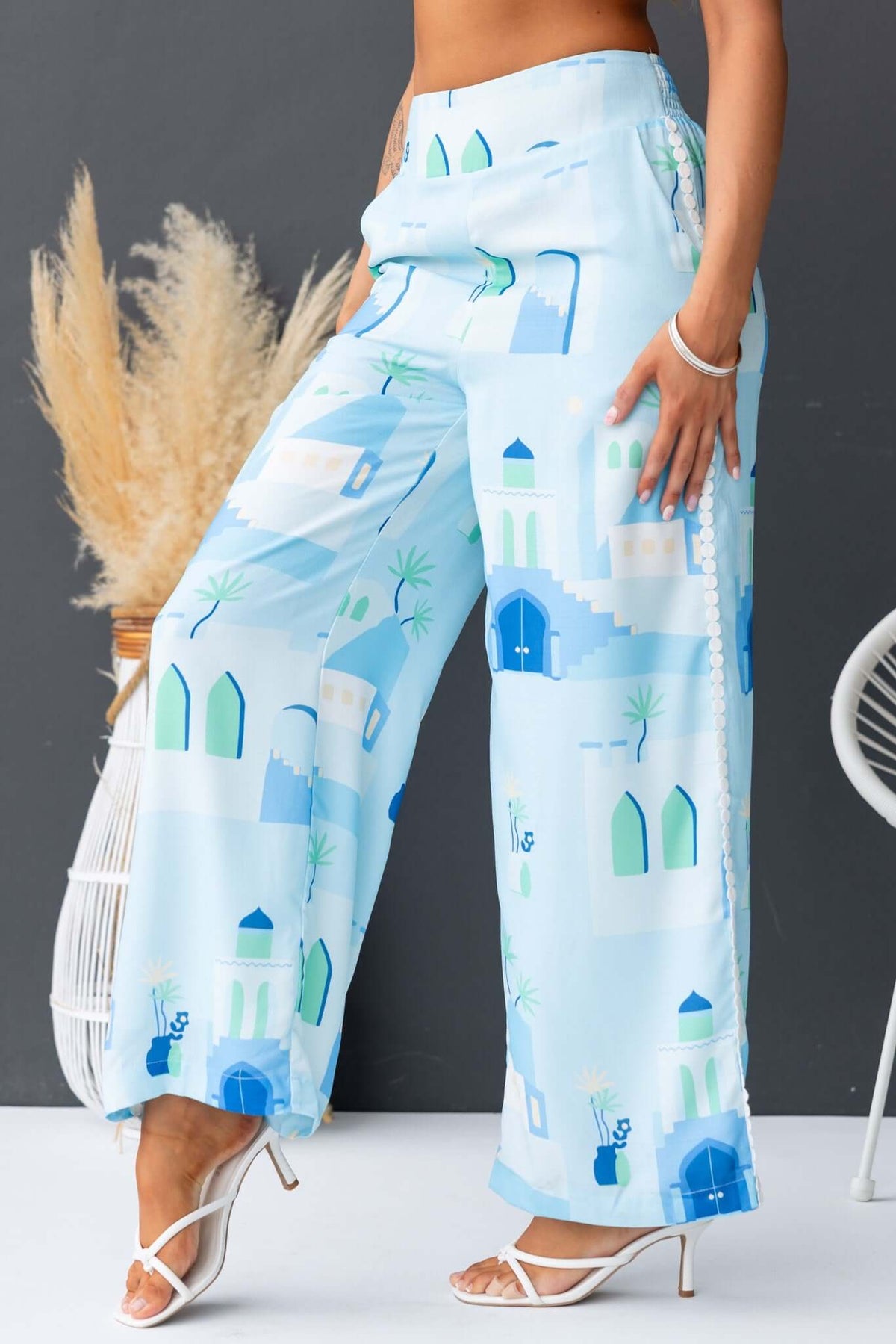 Uriela Pants in light blue with scenic prints, featuring a mid-high waist and elastic waistband, styled for summer fashion.