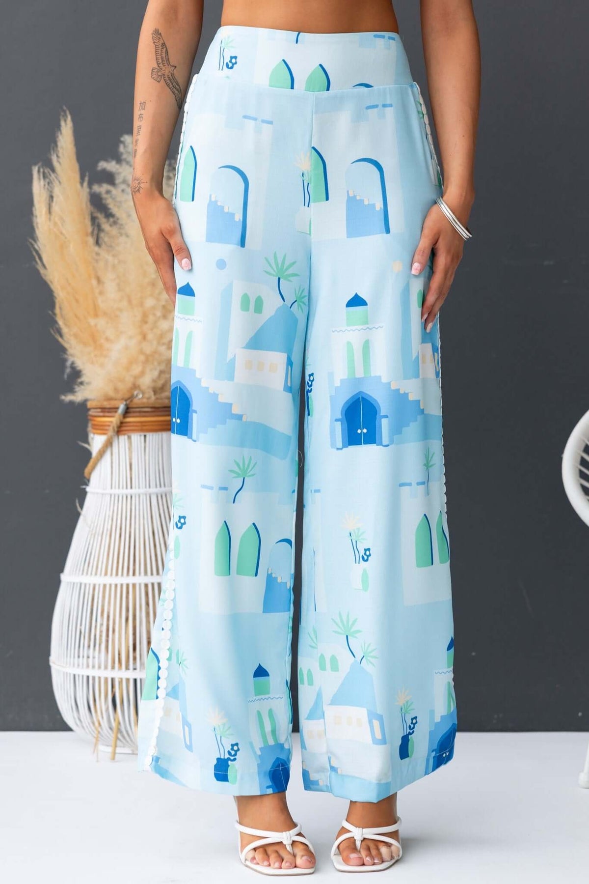 Uriela Pants featuring a mid-high waist fit, elastic waistband, and vibrant blue pattern with pockets, ideal for casual wear.