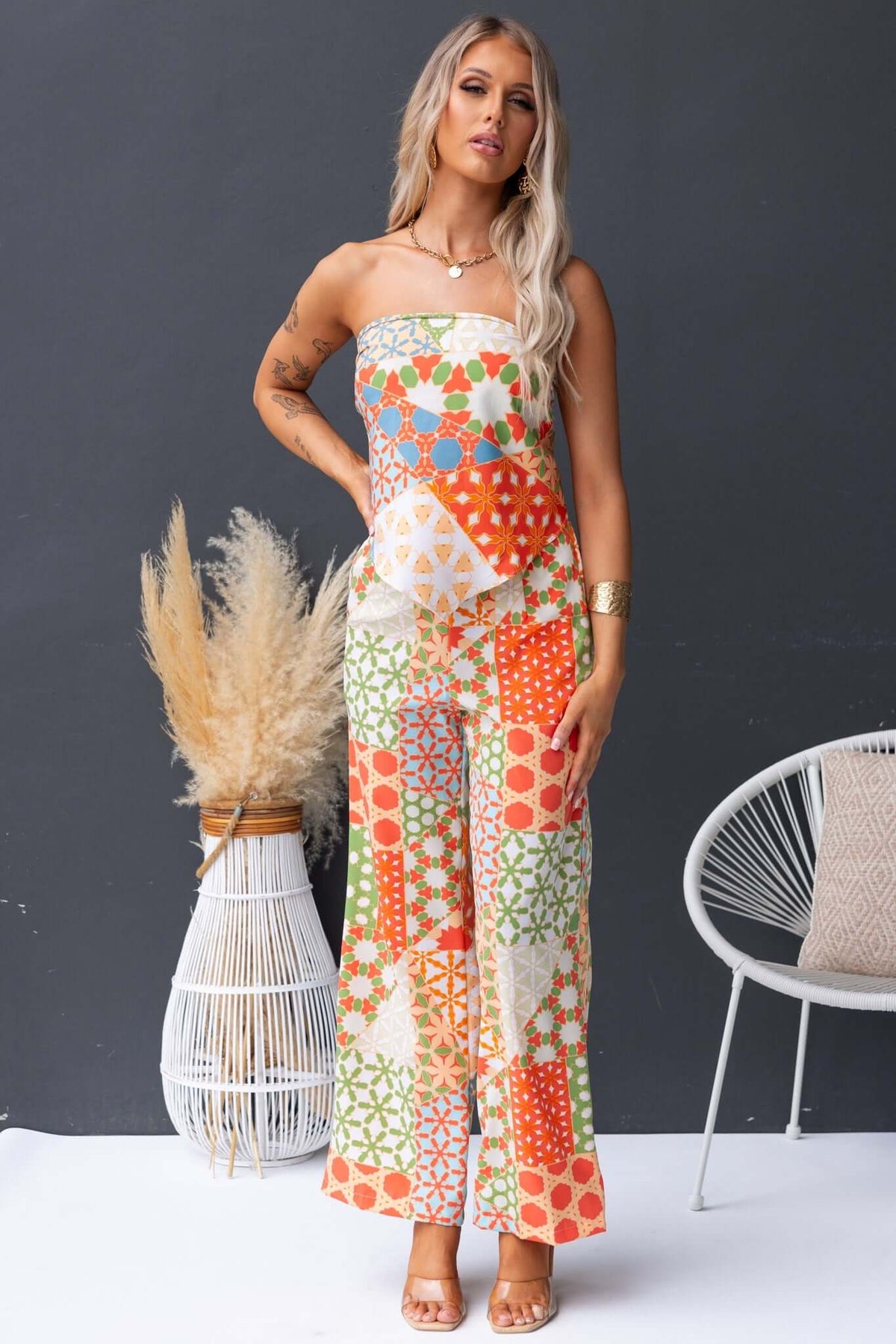 Model wearing a colorful Lorinda Top scarf top with vibrant patterns, showcasing a stylish summer outfit.