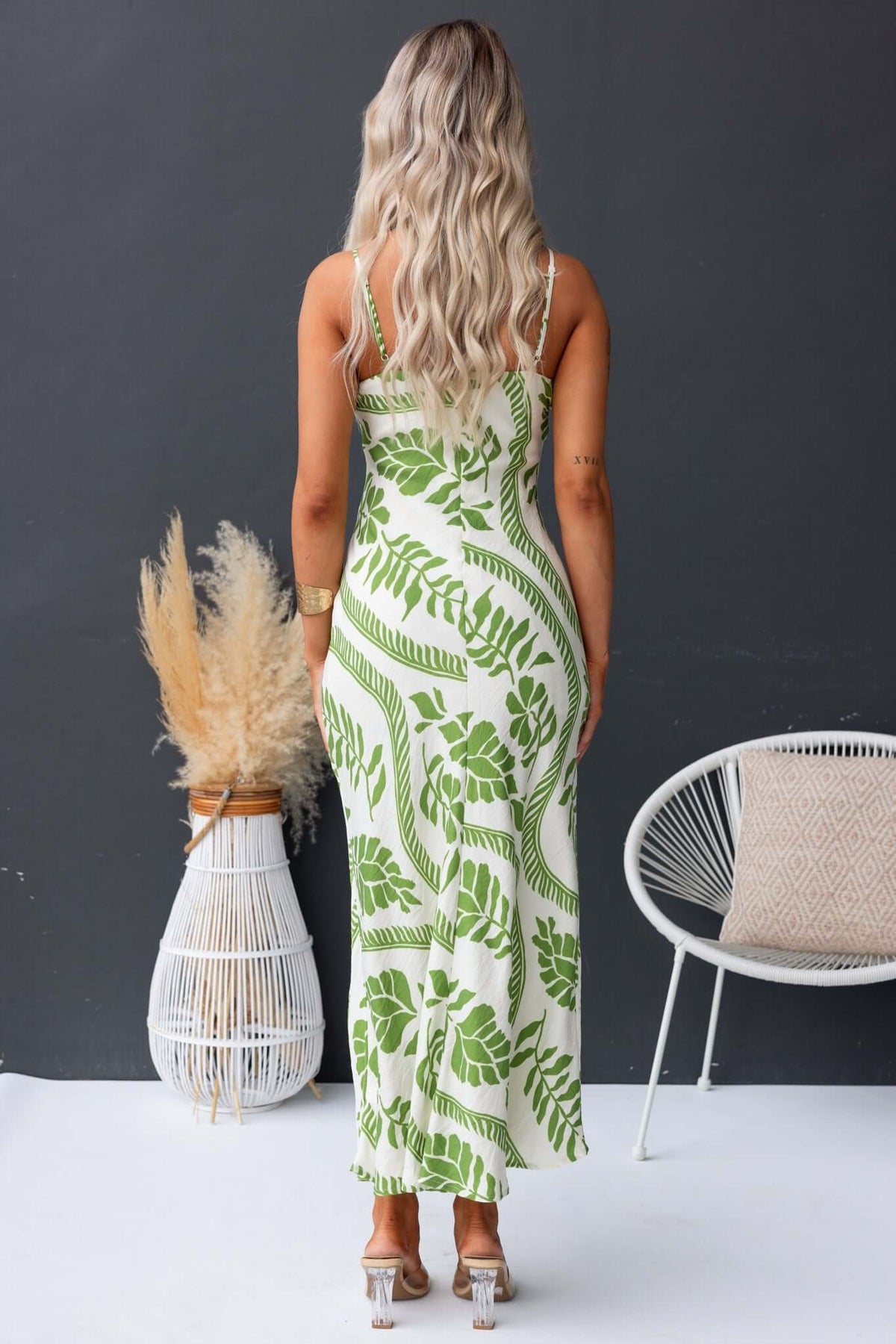 Back view of the Kalinda Maxi Dress featuring adjustable straps and a vibrant green leaf print.