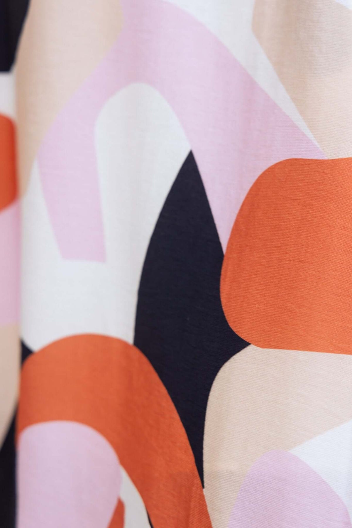 Close-up of patterned fabric featuring bold colors and shapes, perfect for a stylish Modina Midi Dress.
