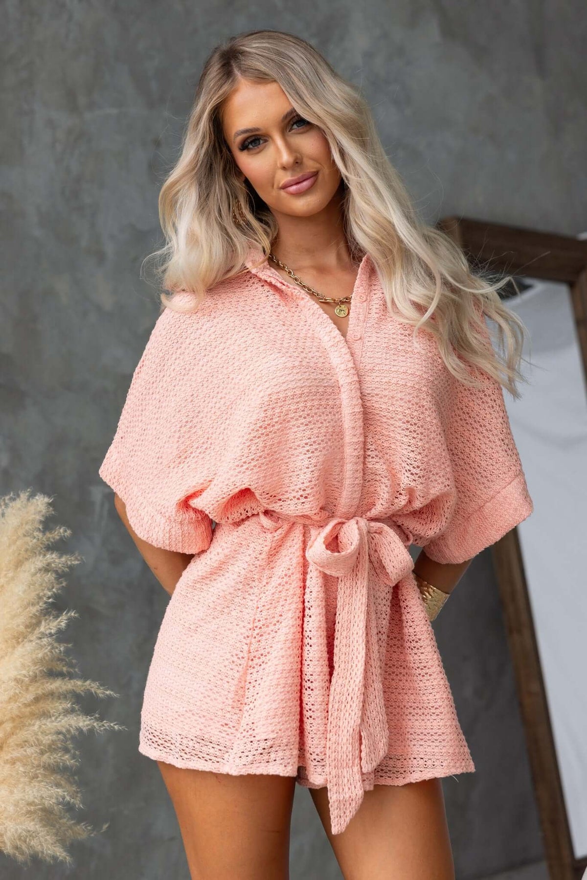 Joner Playsuit in soft pink with collar, button-up front, and removable tie, perfect for a relaxed fit.