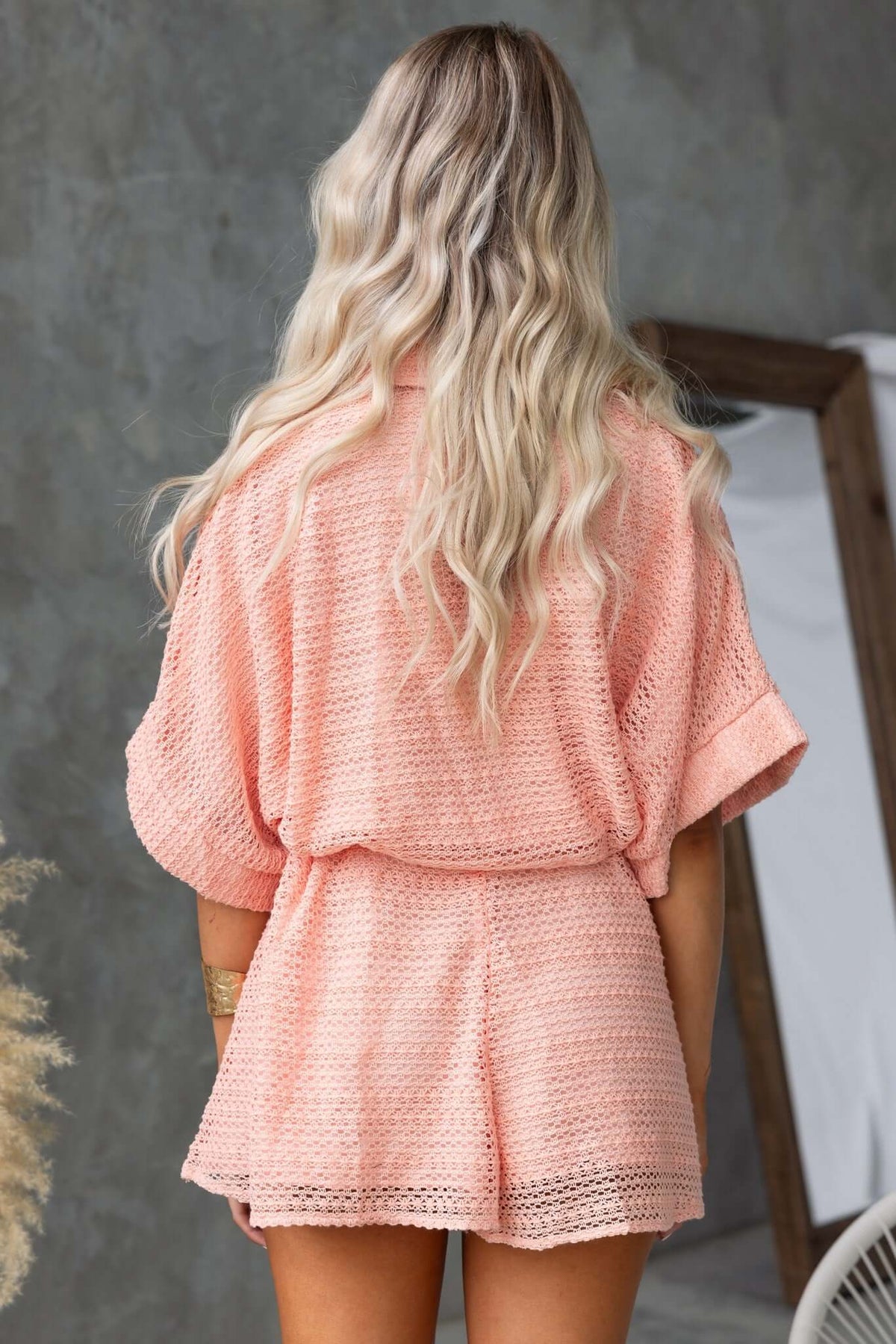 Back view of a woman in a pink Joner Playsuit with a relaxed fit and collar, showcasing casual style.