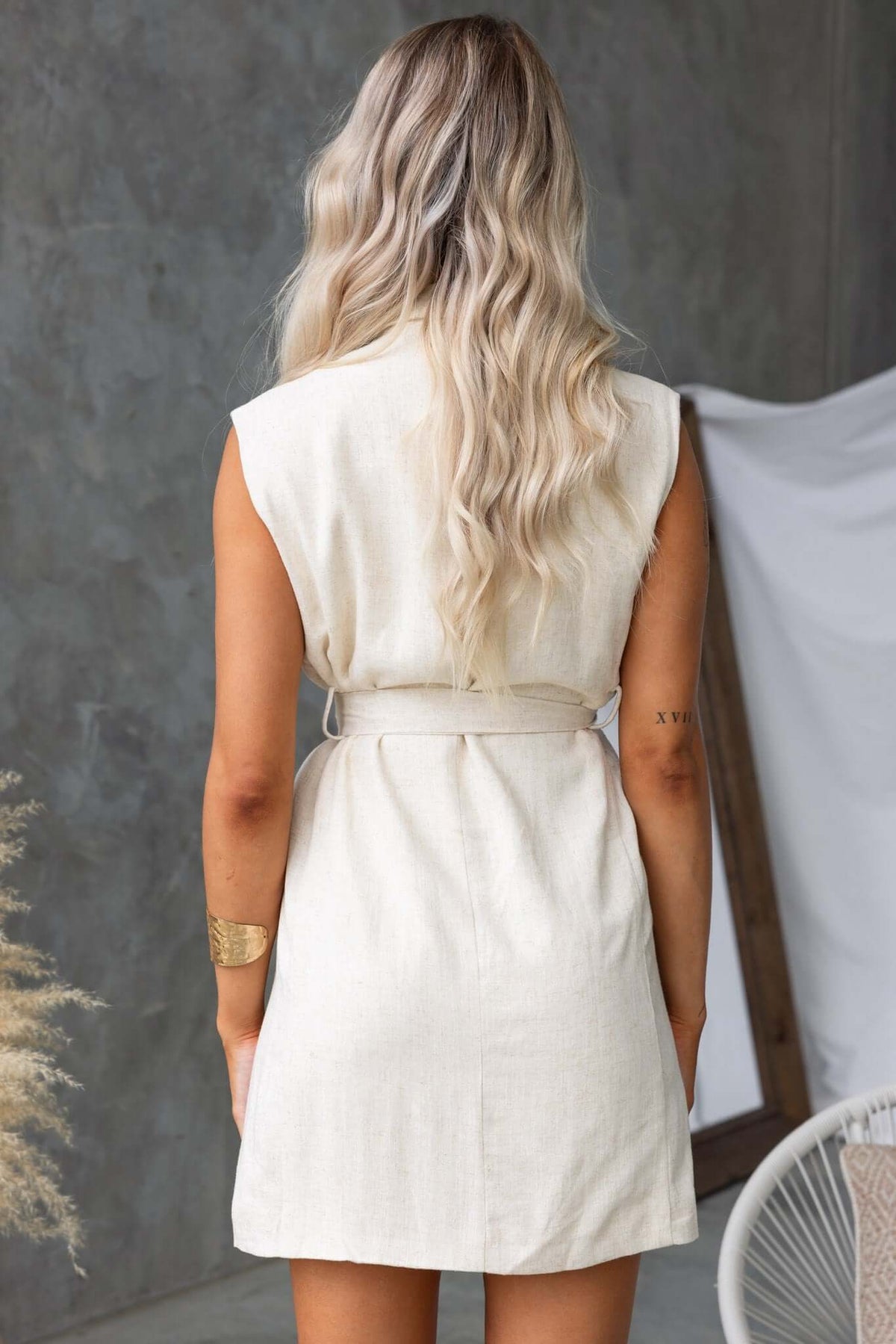 Back view of a model wearing the Stowe Dress, featuring a collar, removable tie, and relaxed fit.