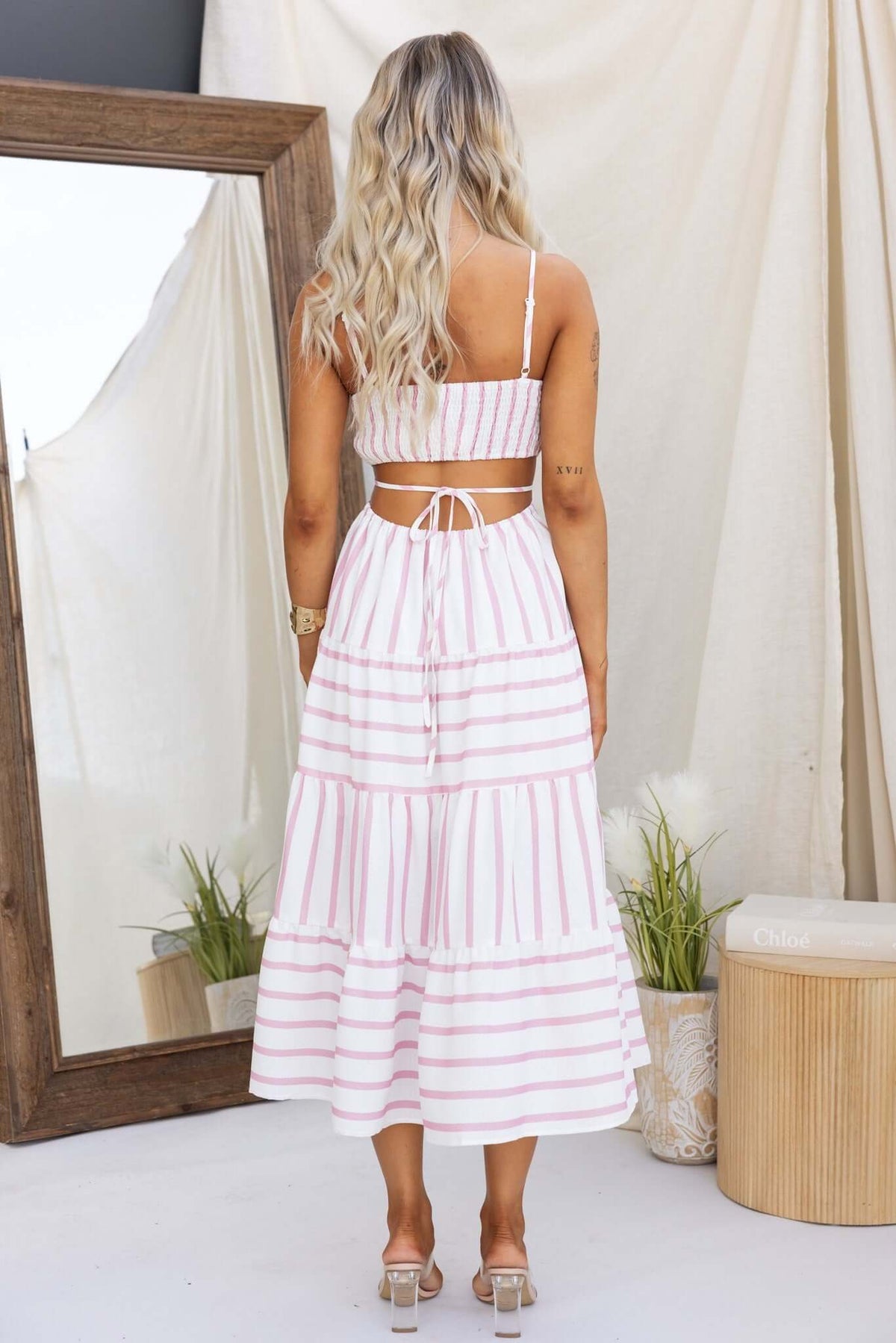 Back view of Brookman Midi Dress featuring adjustable straps, cut-out waist, and striped linen design.