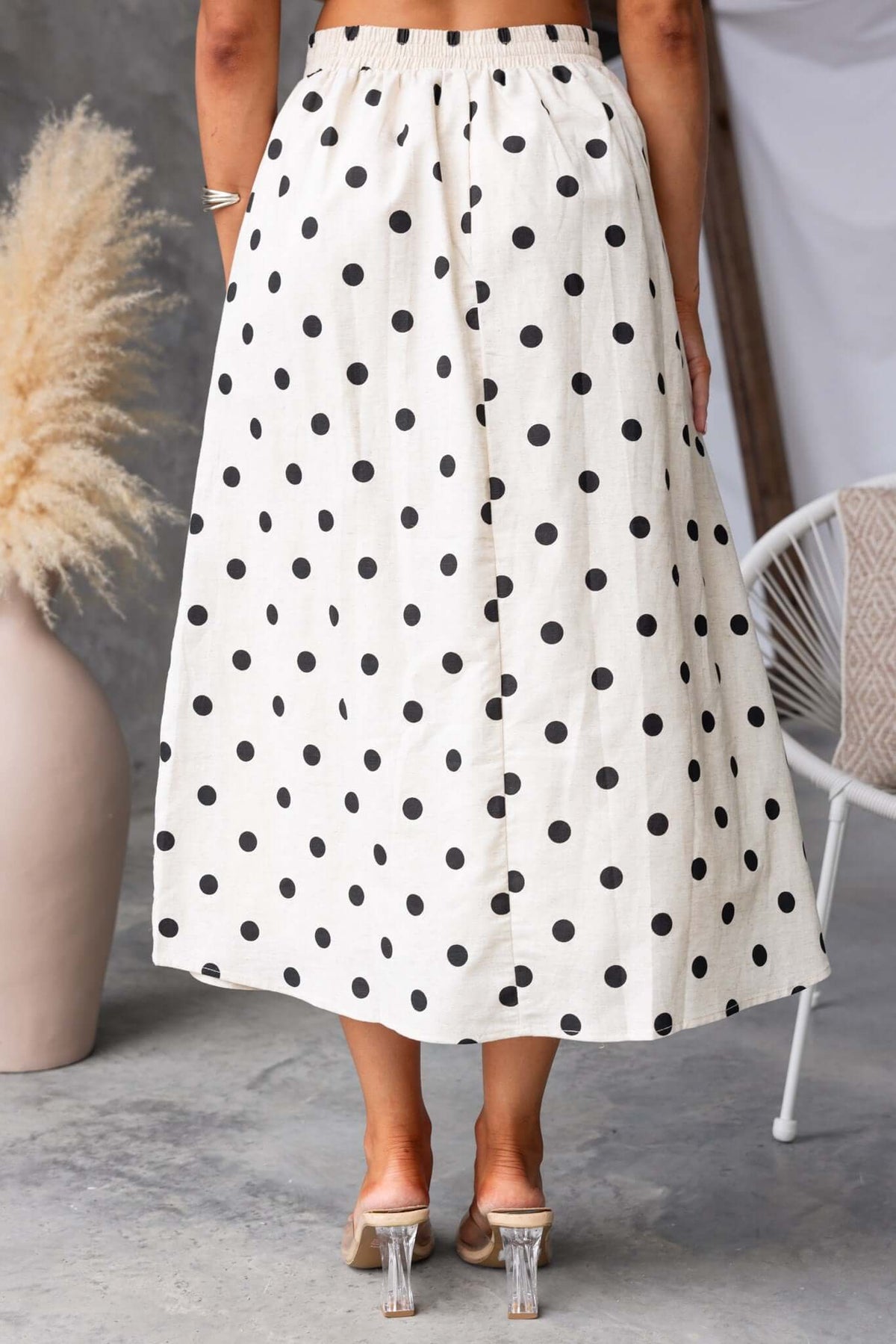Back view of Carrion Midi Skirt featuring a polka dot design, elastic waistband, and pockets.