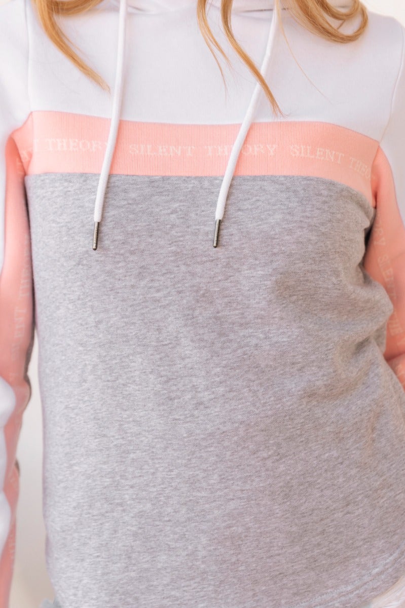 Close-up of Xarles Jumper, a printed hoodie with ribbed sleeves, pink and grey color blocking, and drawstring hood.
