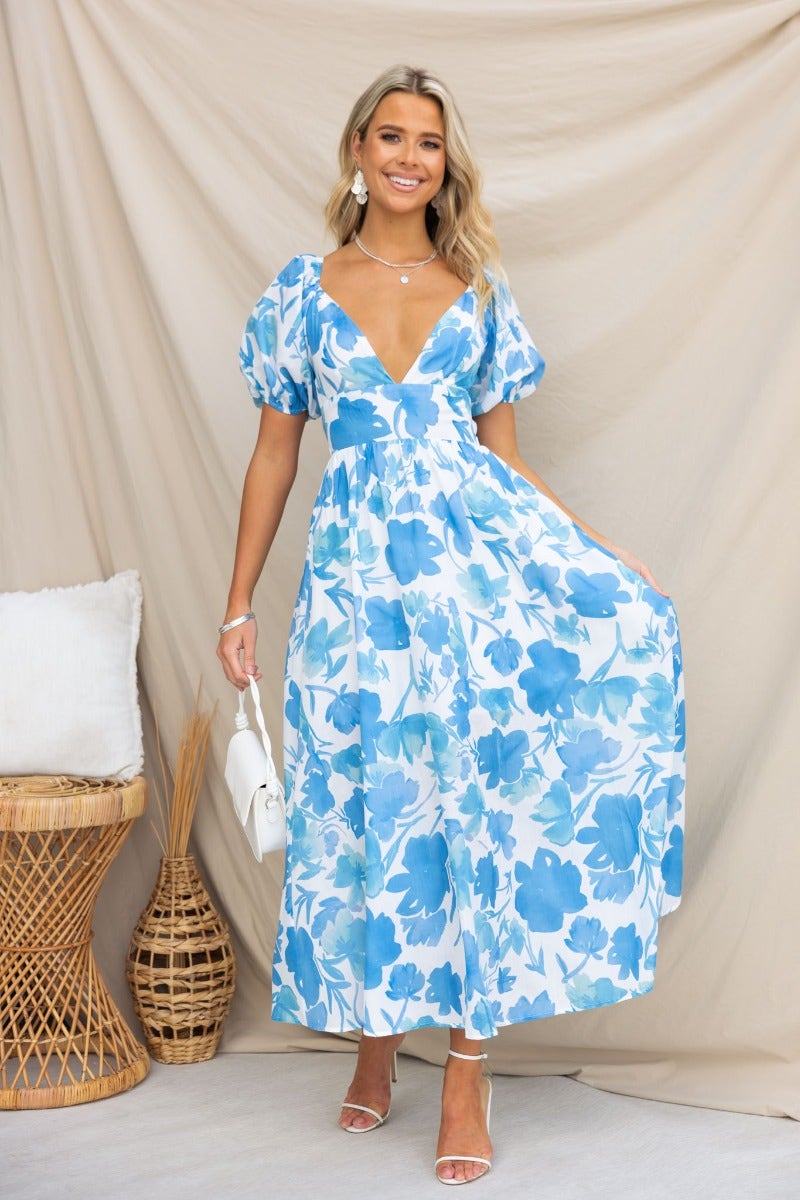 Evalane Maxi Dress in blue floral print, featuring a V-neckline, puff sleeves, and tie detail at the back.