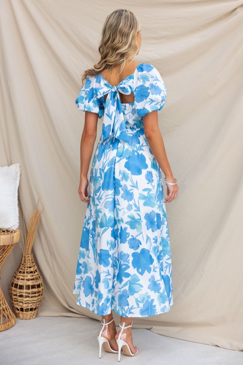 Back view of Evalane Maxi Dress featuring blue floral print, V-neckline, and tie detail at the back.