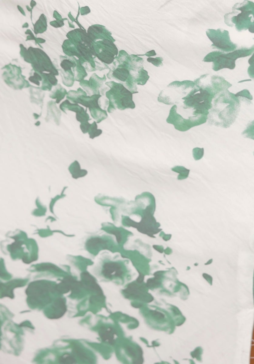 Floral print fabric detail featuring soft green blooms on a white background, ideal for the Maesi Midi Dress.