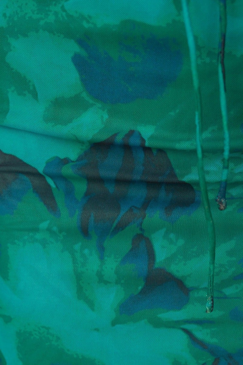 Close-up of floral print fabric in green tones for the Bamba Midi Dress, showcasing the vibrant pattern and adjustable ties.