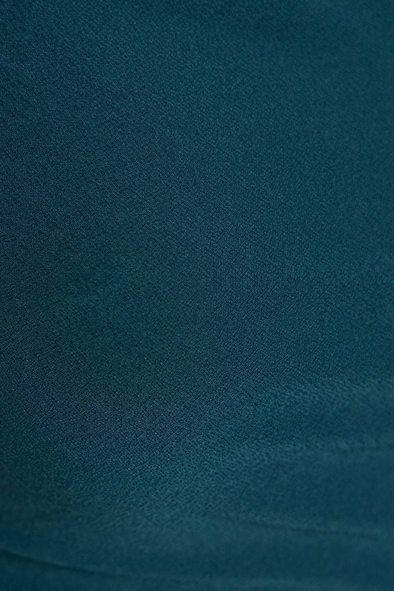 Close-up view of teal polyester fabric showcasing smooth texture and stretch, suitable for the Verra Midi Dress.