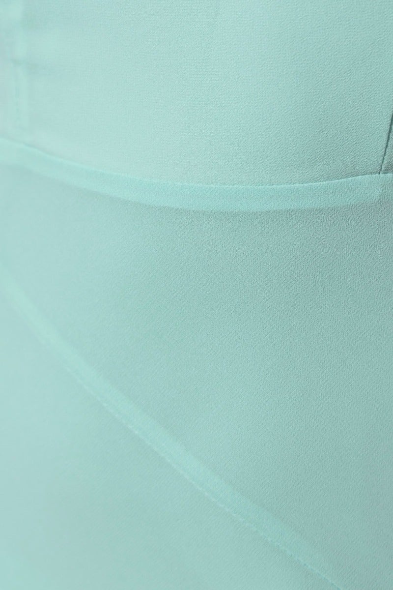 Close-up detail of mint green fabric showcasing smooth texture and tailored seams of the Cinzia Maxi Dress.
