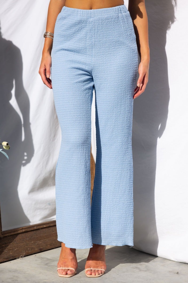 Light blue textured Brozala Pants with mid-high waist and elastic waistband, perfect for a comfortable fit.