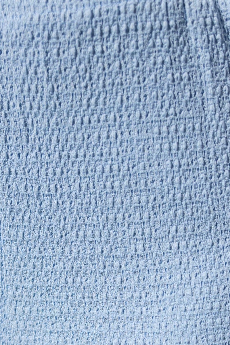 Textured light blue fabric close-up of Brozala Pants featuring stretch material and mid-high waist design.