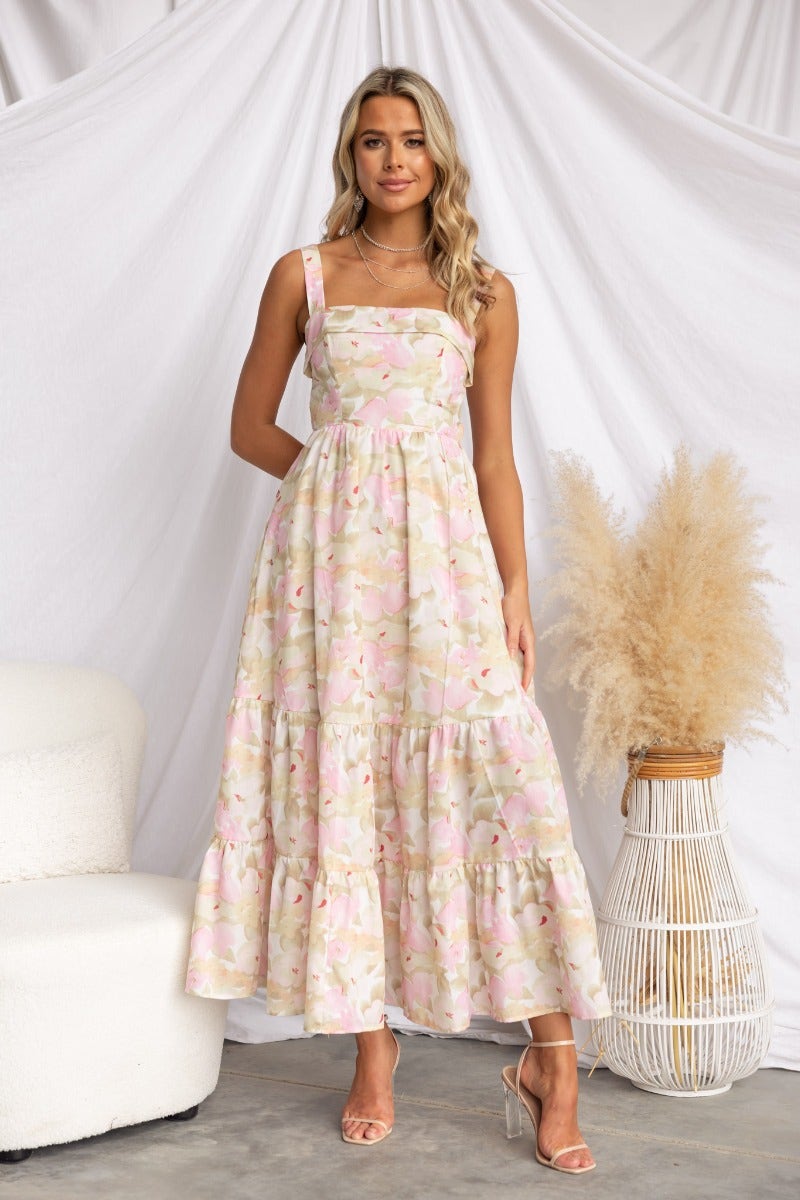 Light Hearted maxi dress with floral print, boning, and a tiered skirt, worn by a model in a stylish setting.