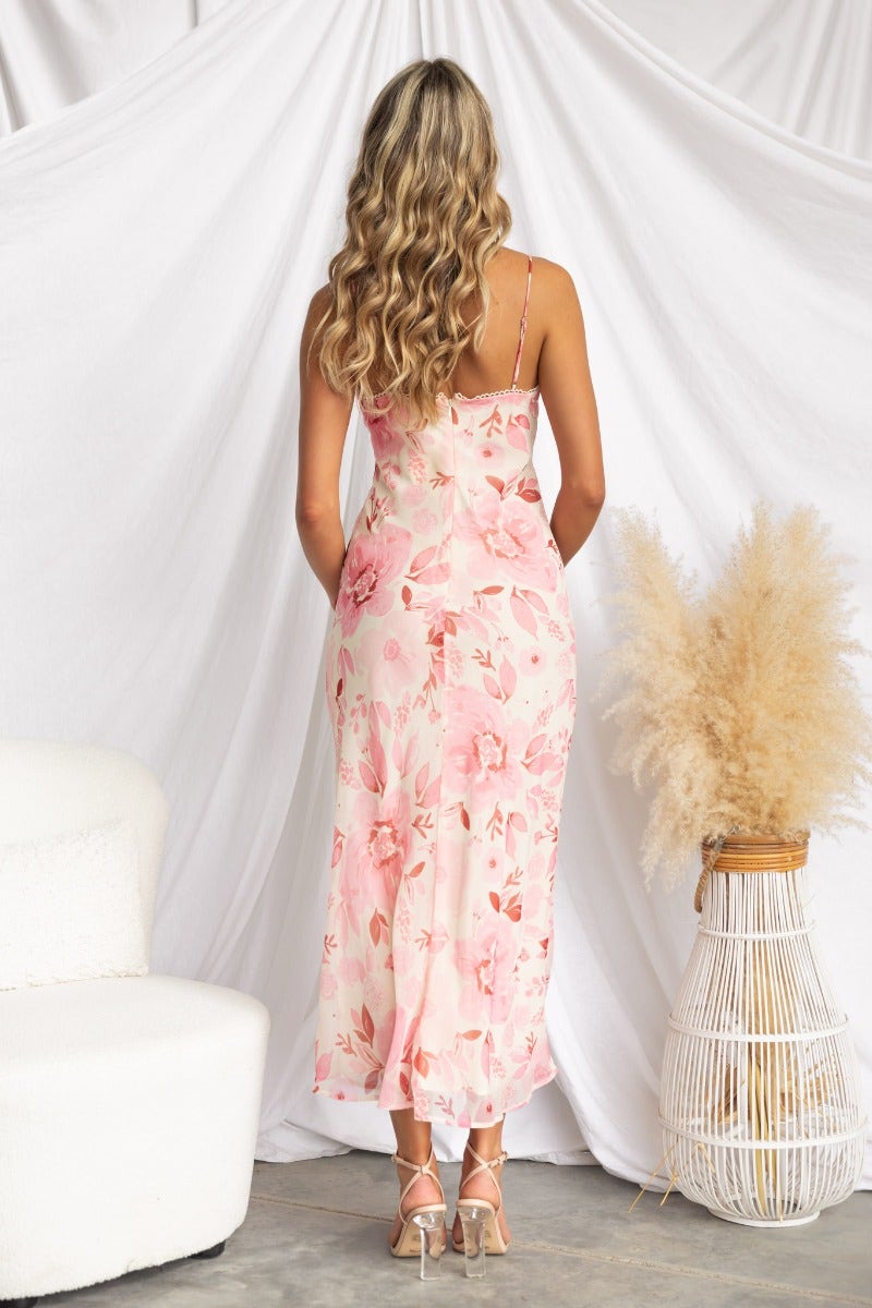 Back view of Jasia midi dress with floral print, adjustable straps, styled with a soft white backdrop.