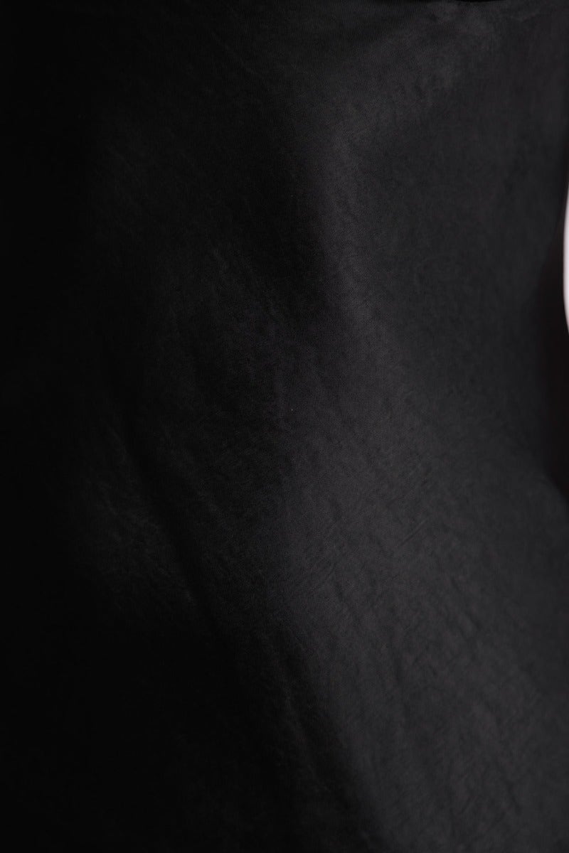 Close-up of the smooth black satin fabric of the Sweet Essence Dress, showcasing its elegant texture and shine.