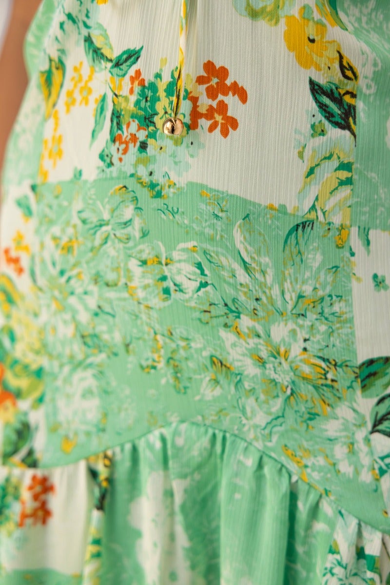 Close-up of Wildest Dreams Maxi Dress showcasing vibrant floral print and elegant tie detail.
