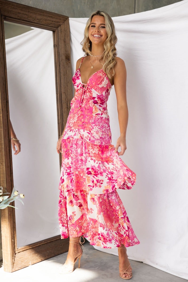 Model wearing Wildest Dreams Maxi Dress with floral print and adjustable straps in a bright, airy setting.