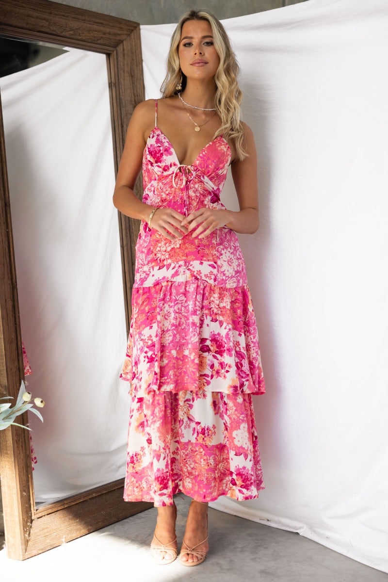 Floral print Wildest Dreams maxi dress with adjustable straps and tie detail, showcased by a model in a bright setting.