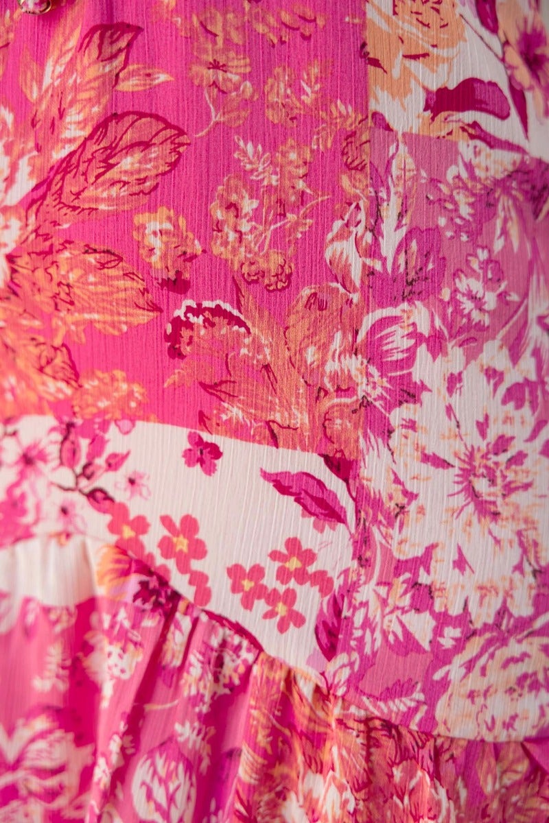 Close-up of vibrant floral print in pink hues on the Wildest Dreams Maxi Dress, showcasing its detailed fabric texture.