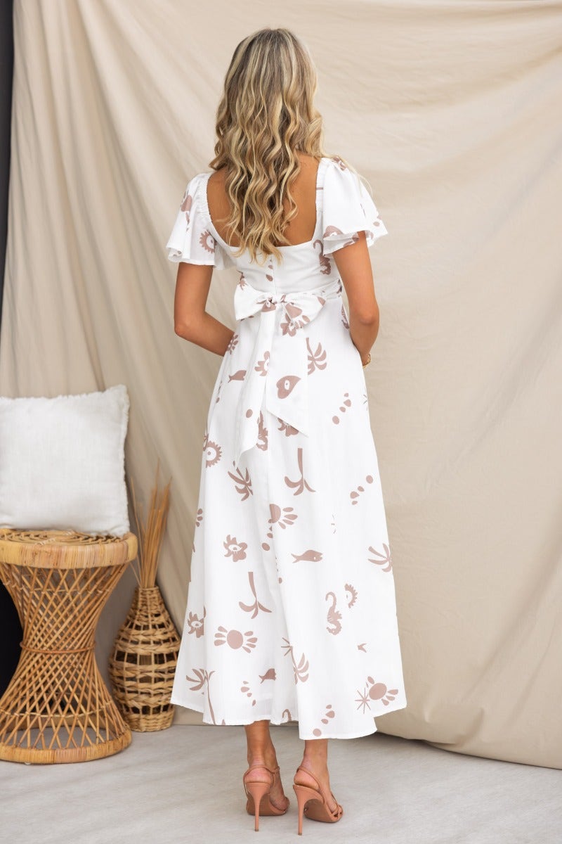 Fermina Wrap Maxi Dress, back view, featuring flutter sleeves and a wrap tie, styled against a neutral backdrop.