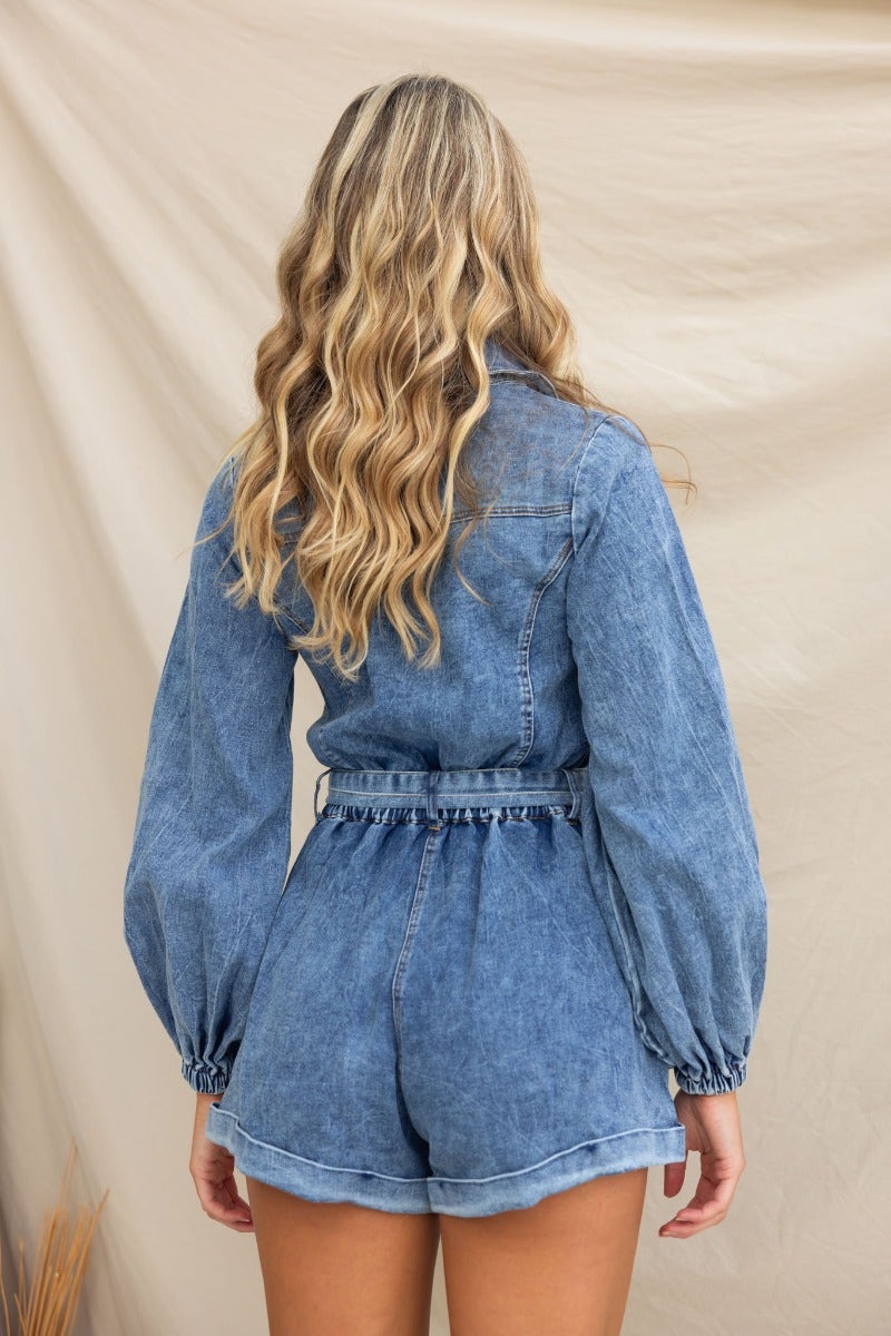 Back view of a woman wearing the On Track Denim Playsuit, featuring a button-up front and elastic cuffs.