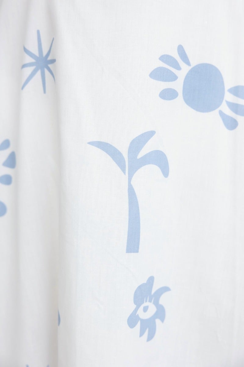 Close-up of light blue floral and abstract patterns on a white fabric, ideal for a feminine wrap maxi dress.