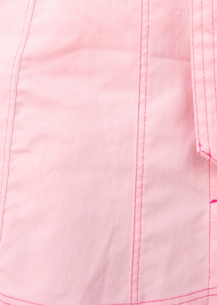 Close-up of pink denim fabric showcasing detailed stitching and texture, ideal for trendy apparel designs.