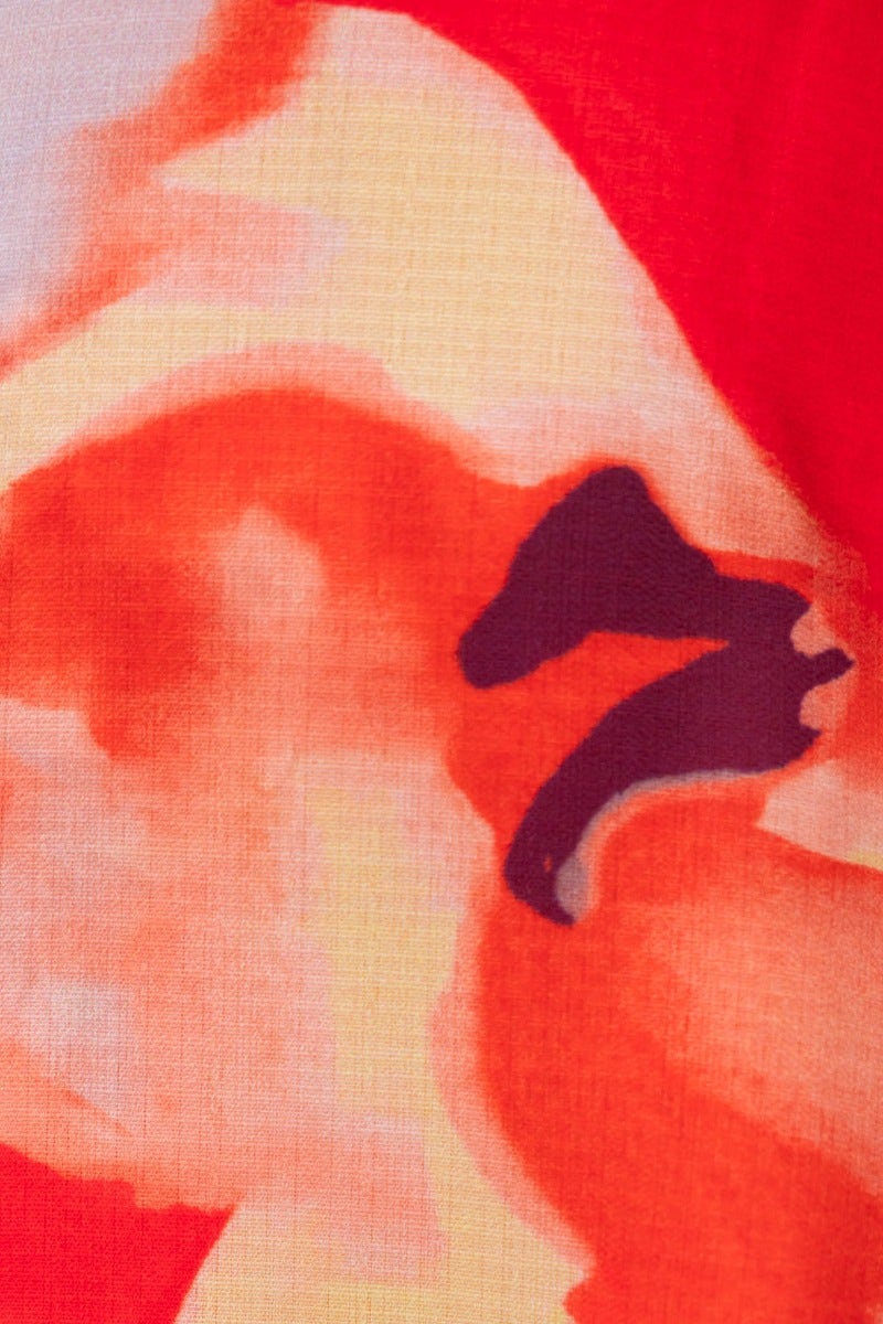 Close-up of vibrant floral print detail on a Scorpio Maxi Dress, featuring bold red and orange hues.