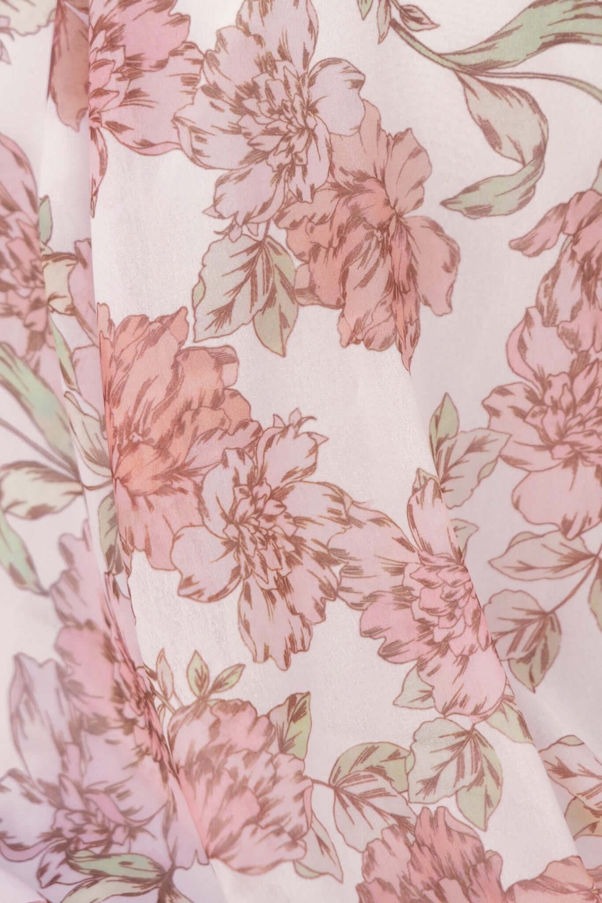 Close-up of light chiffon fabric featuring a floral pattern in soft pink and green tones, perfect for a feminine maxi dress.