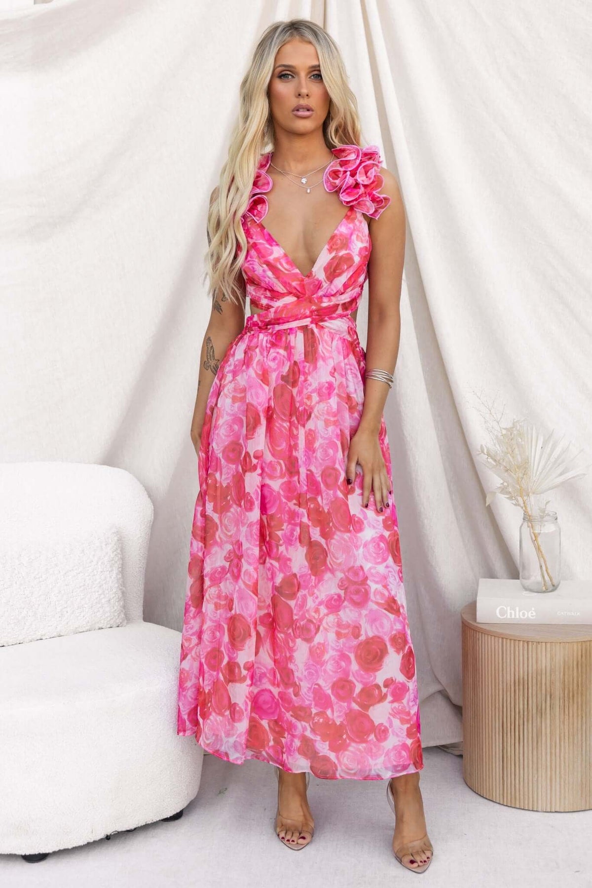 Model wearing Rosie Maxi Dress with ruffle straps and pink floral design, featuring V-neckline and lace-up back.