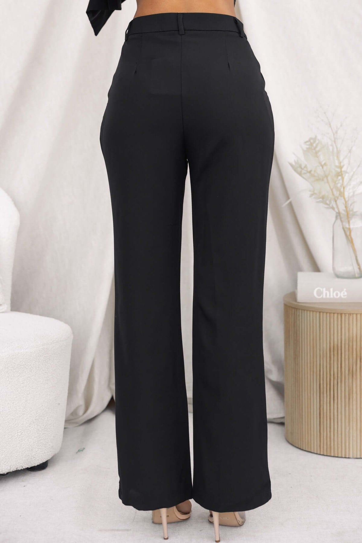 Back view of Ulani black pants with mid-high waist, tailored fit, and pockets, perfect for stylish casual wear.