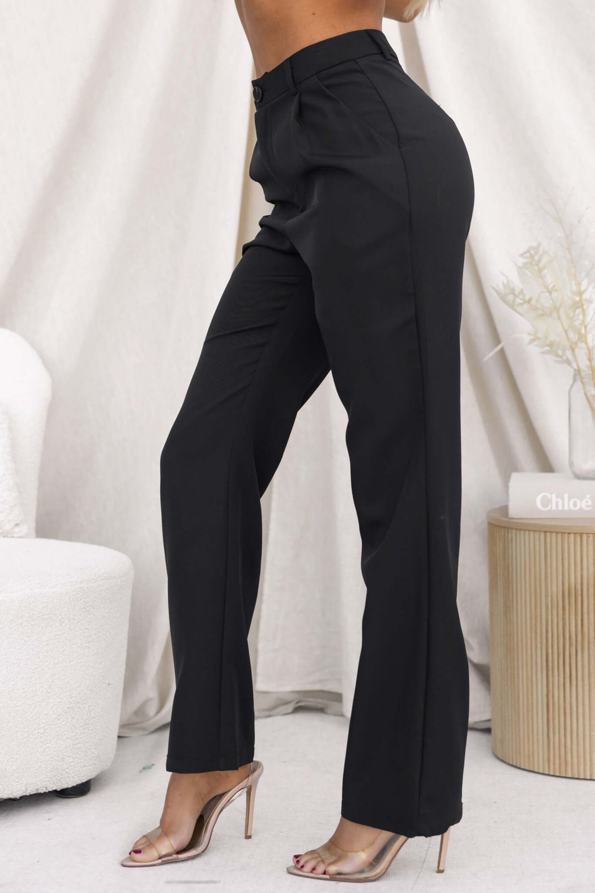 Ulani Pants in black featuring a mid-high waist fit and sleek design, styled for a chic look.