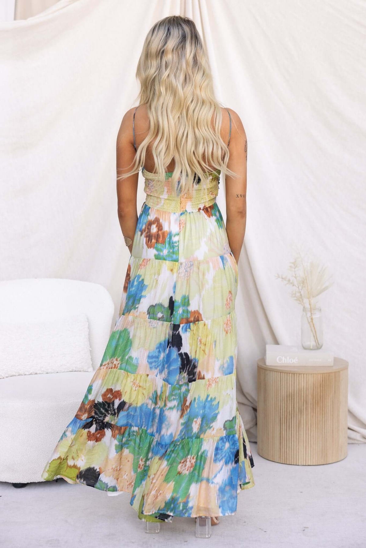 Back view of a woman wearing the Ottawa Maxi Dress featuring floral patterns and adjustable straps.