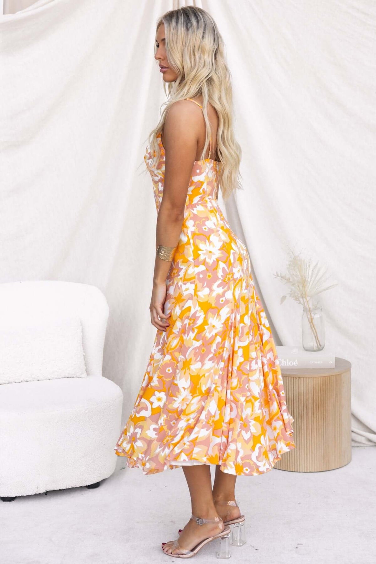 Model wearing the Sandra Midi Dress in a vibrant floral print, showcasing adjustable straps and flowing silhouette.