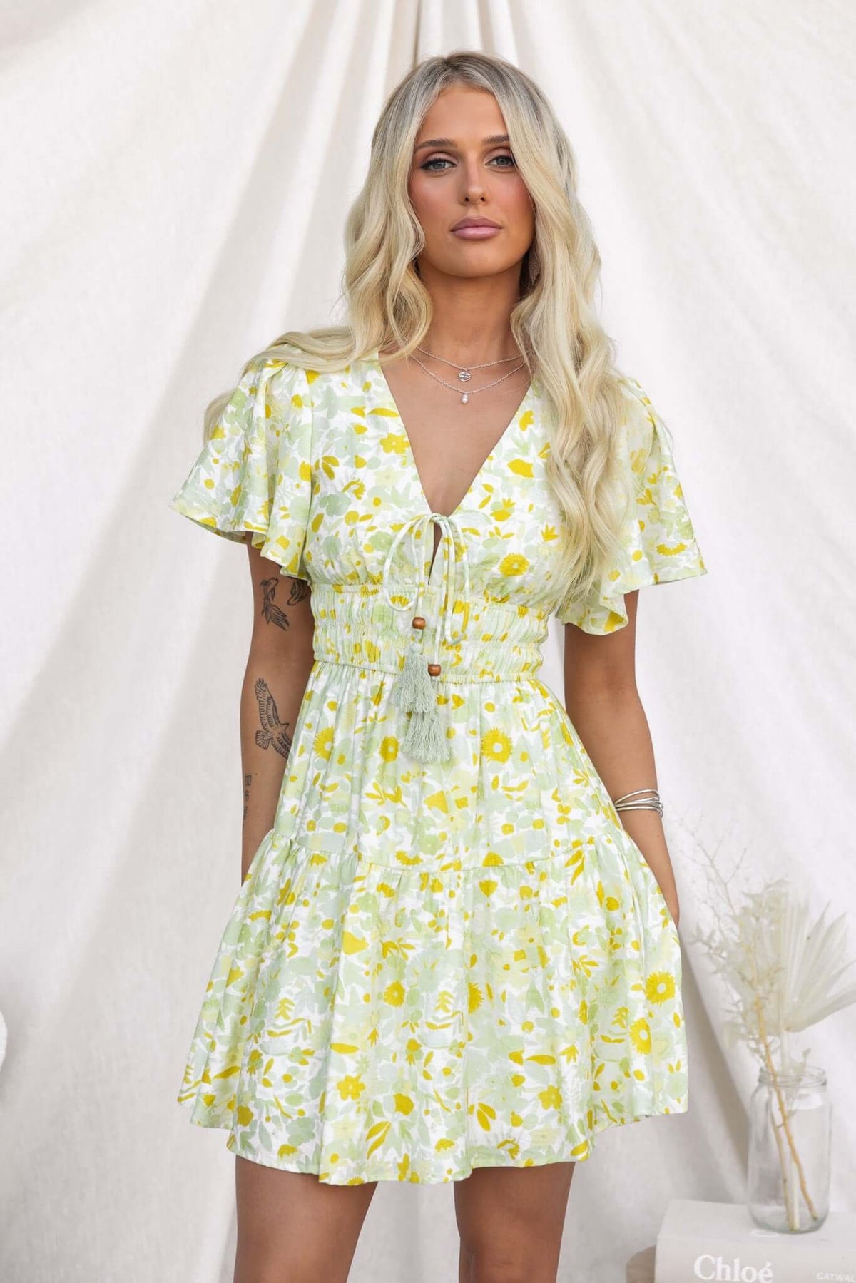 Isha Dress featuring a V-neckline, tie at bust, elastic waistband, and floral print, perfect for summer outings.