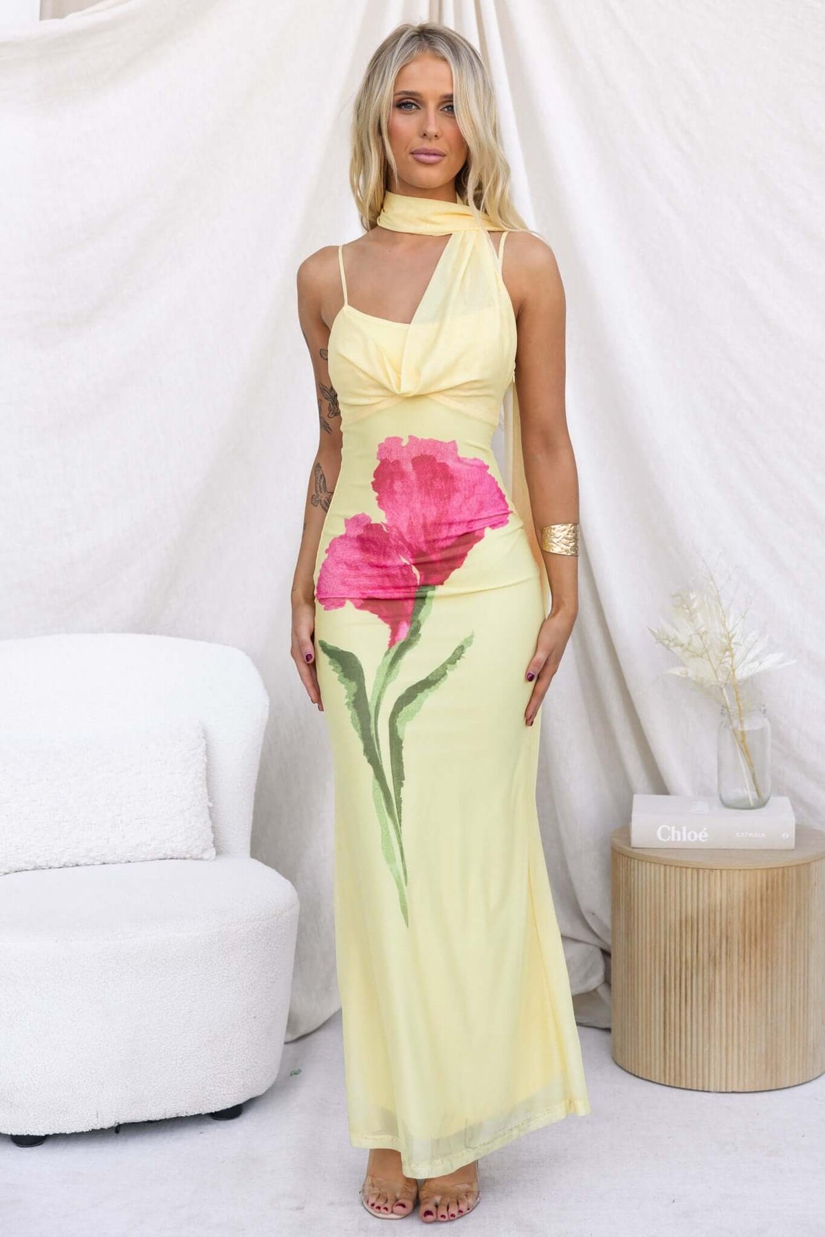 Model wearing Larne Maxi Dress with floral print, featuring a wrap style neckline and adjustable straps in a bright yellow color.