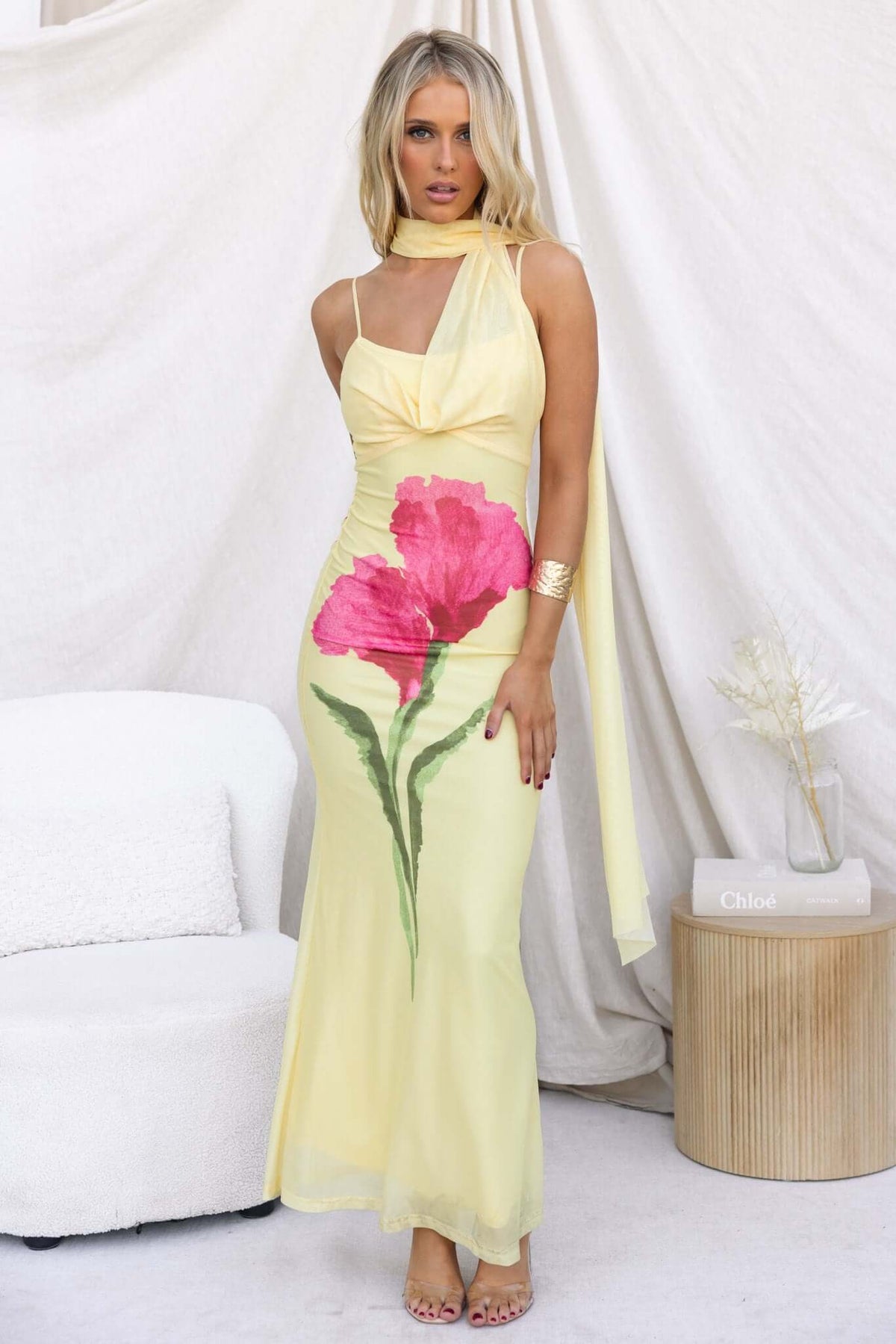 Model wearing a Larne Maxi Dress in yellow with a floral print, featuring adjustable straps and a wrap style neckline.