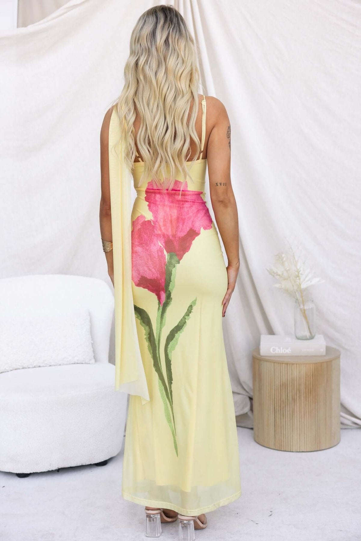 Larne Maxi Dress featuring a wrap style neckline and adjustable straps with colorful flower print on a yellow mesh fabric.