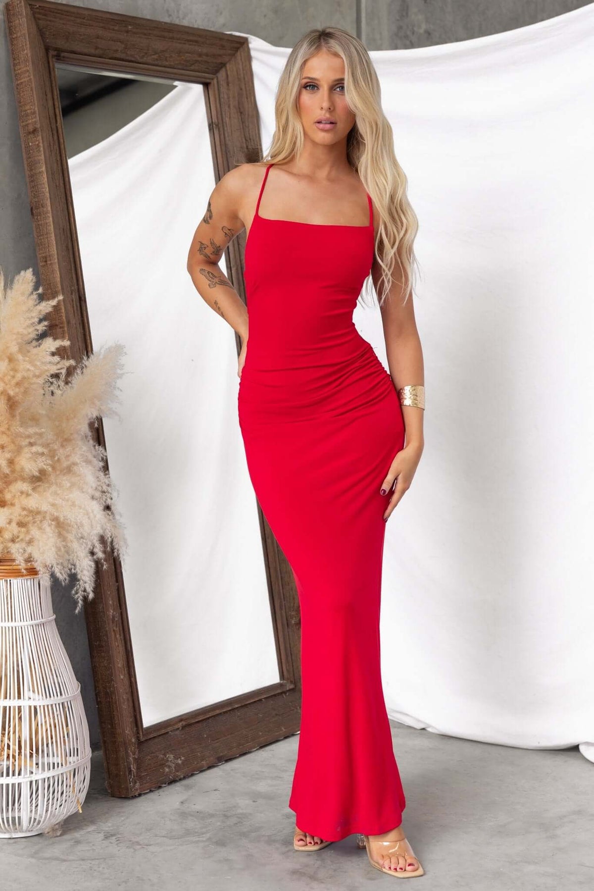 Model wearing a red Perris Maxi Dress with adjustable straps, styled against a neutral backdrop.
