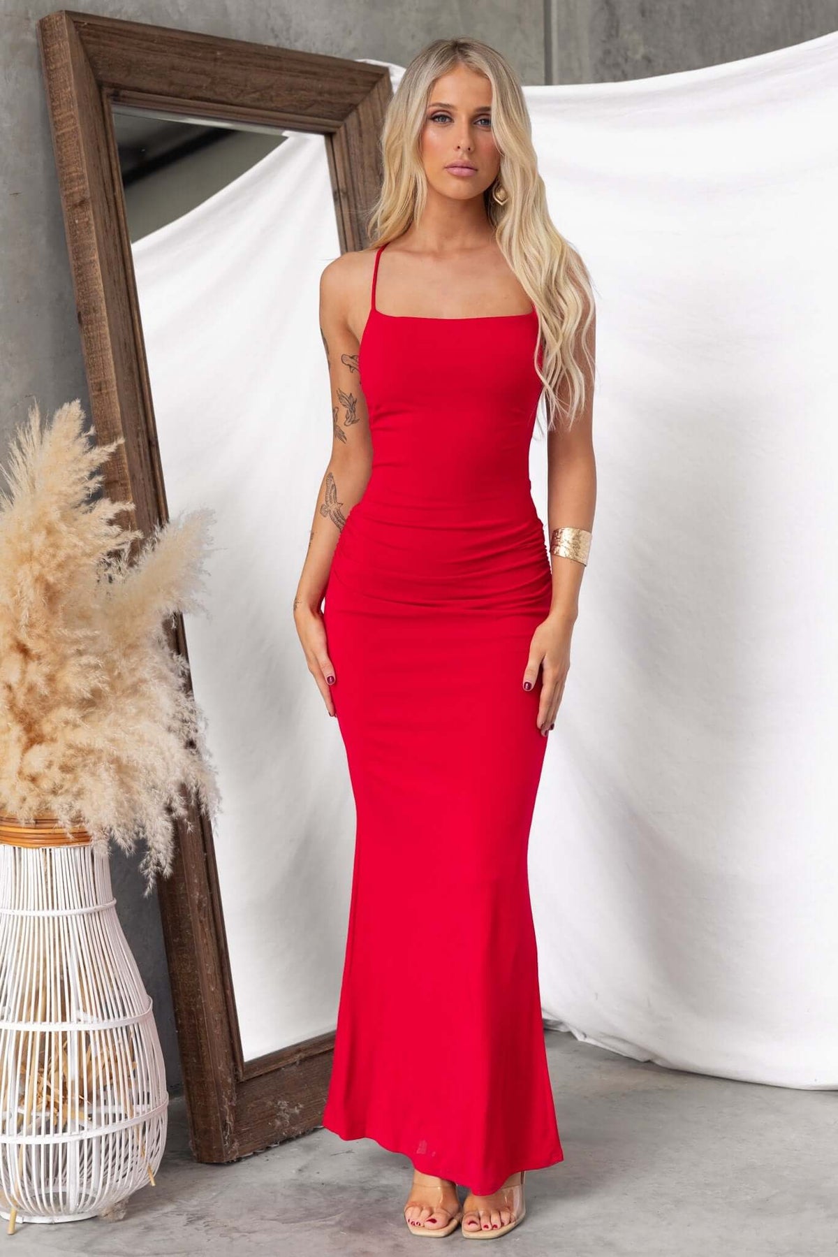 Model wearing a red Perris Maxi Dress with adjustable straps and fitted design, showcasing a stylish look.