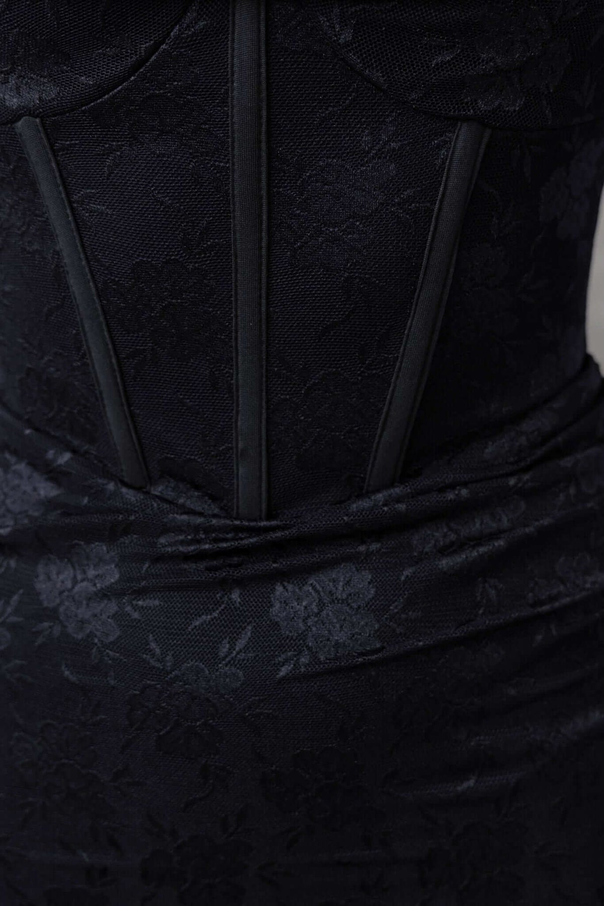 Close-up of the Pasco Dress featuring floral mesh fabric, boning details, and elegant layered design in black.