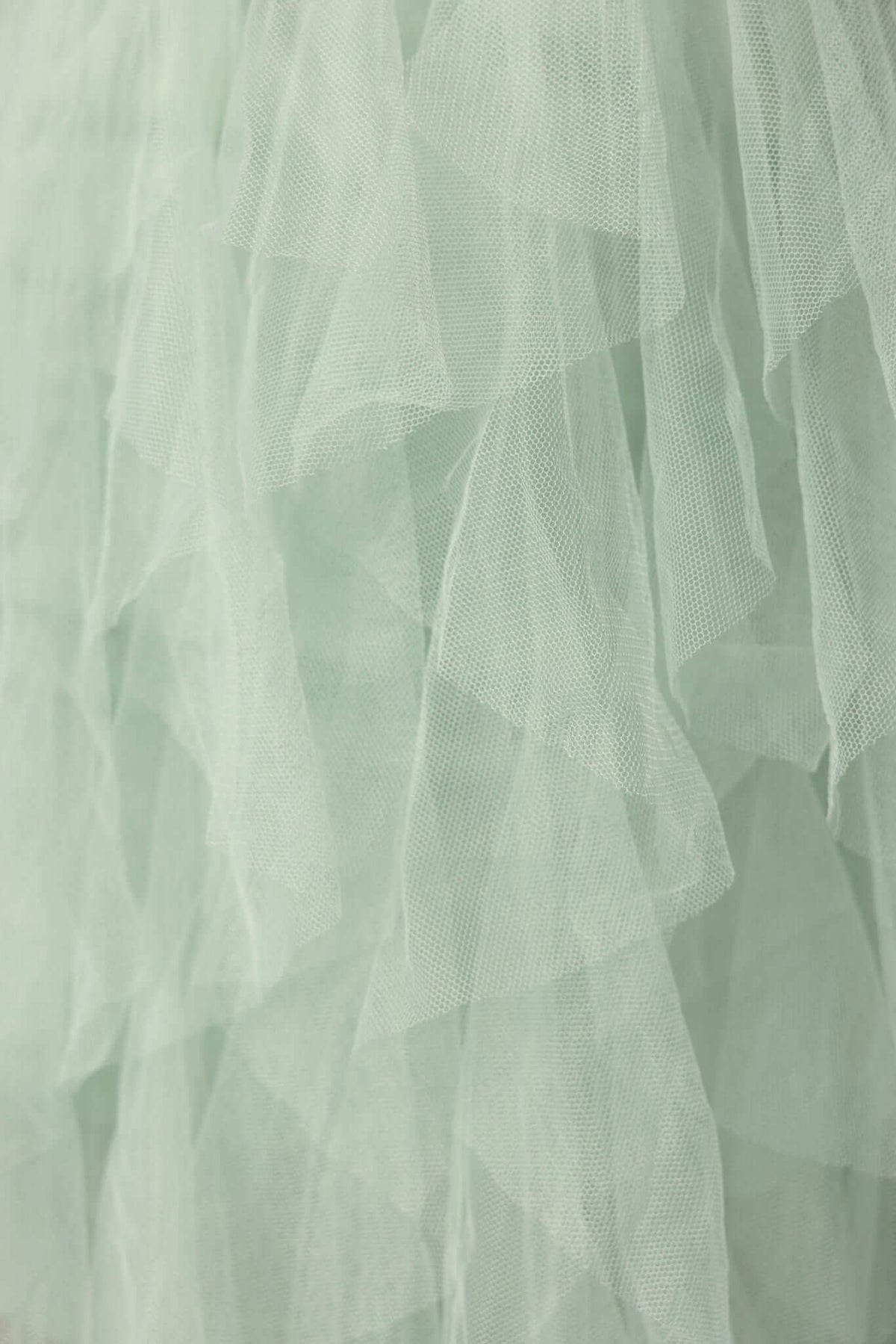 Close-up of soft mint tulle ruffles, showcasing the textured layers perfect for a stylish maxi dress.