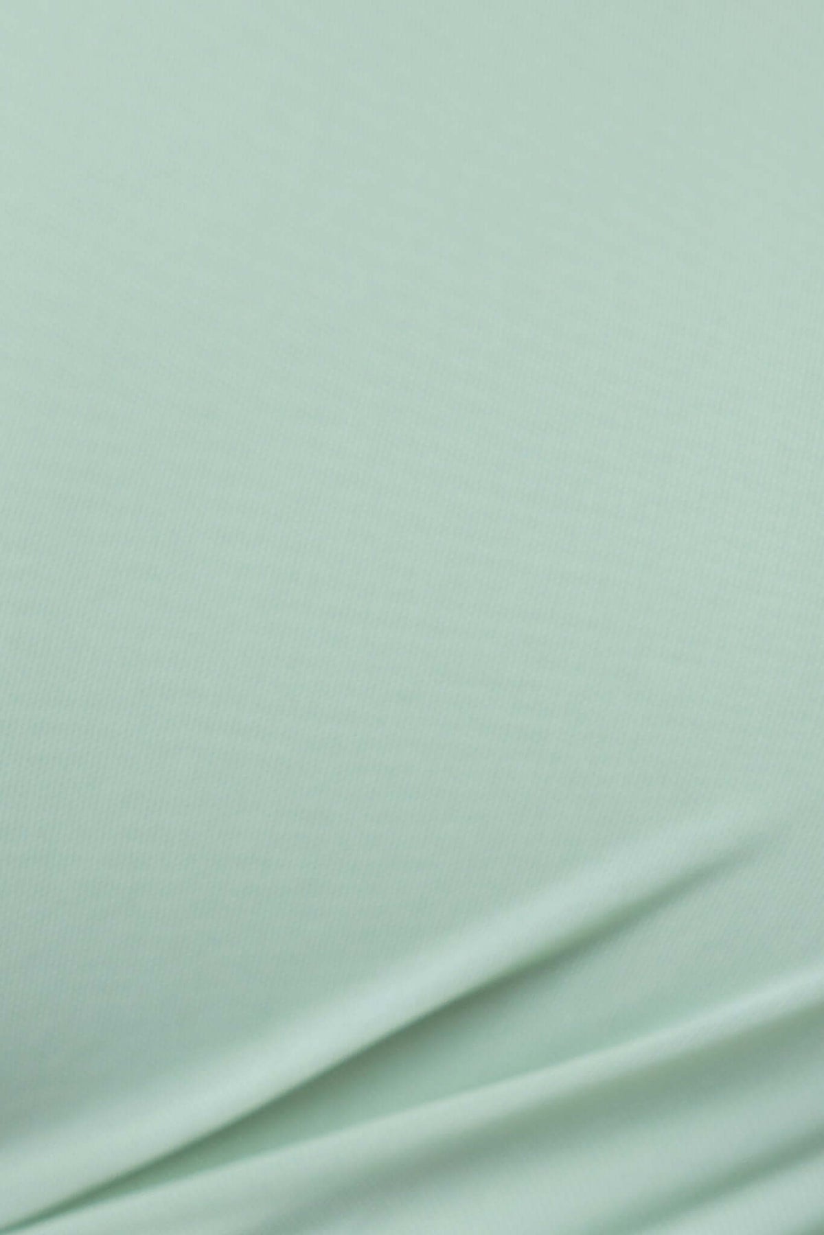 Close-up of soft, stretchy fabric in mint green, showcasing smooth texture ideal for dresses.