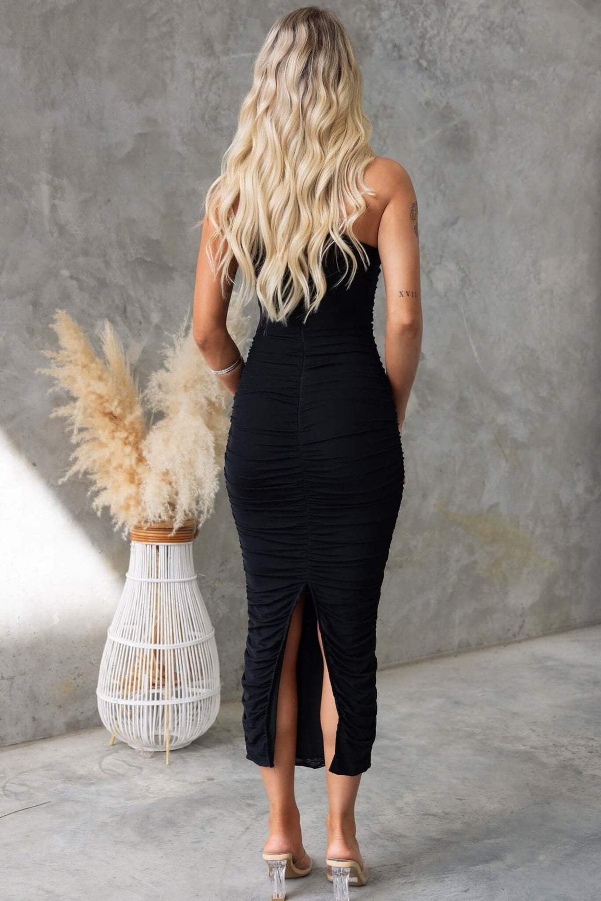 Back view of model wearing Stolen Kiss Maxi Dress with one-shoulder neckline and ruching, highlighting the split and stretch material.
