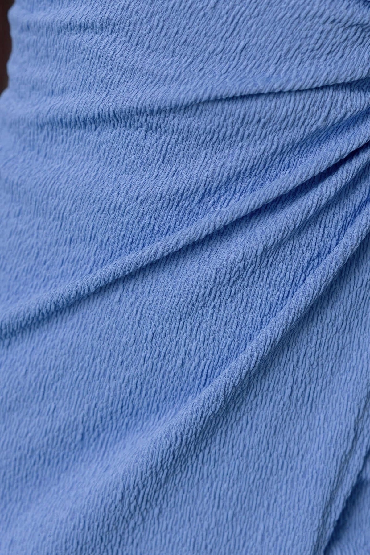 Close-up of light blue textured fabric of the Romney Maxi Dress, showcasing the softness and draping design details.